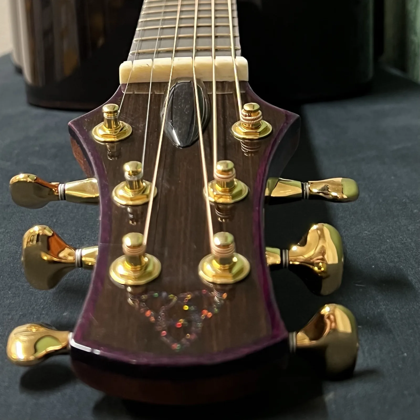 Looking down the headstock toward the nut, with the triquetra inlay catching the light